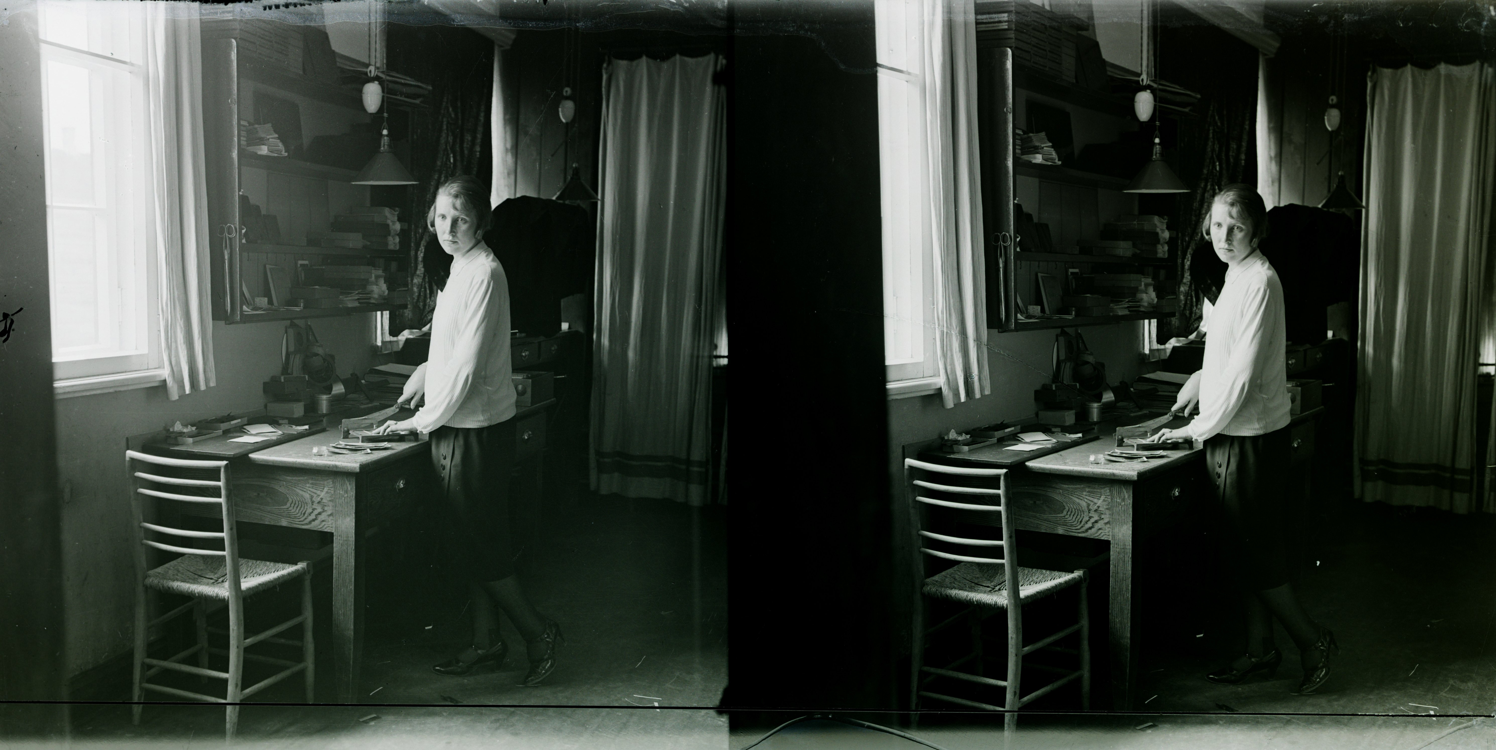 Posti ja Koidu tänava nurgal asunud Jaan Rieti fotoateljee sisevaade, esiplaanil ateljeetööline, laual fotode ja negatiivide viimistlusvahendid, tagaplaanil akna ääres laual negatiivide retuššimispult, u 1920–30. Jaan Riet, stereonegatiiv, EFA.4-6569